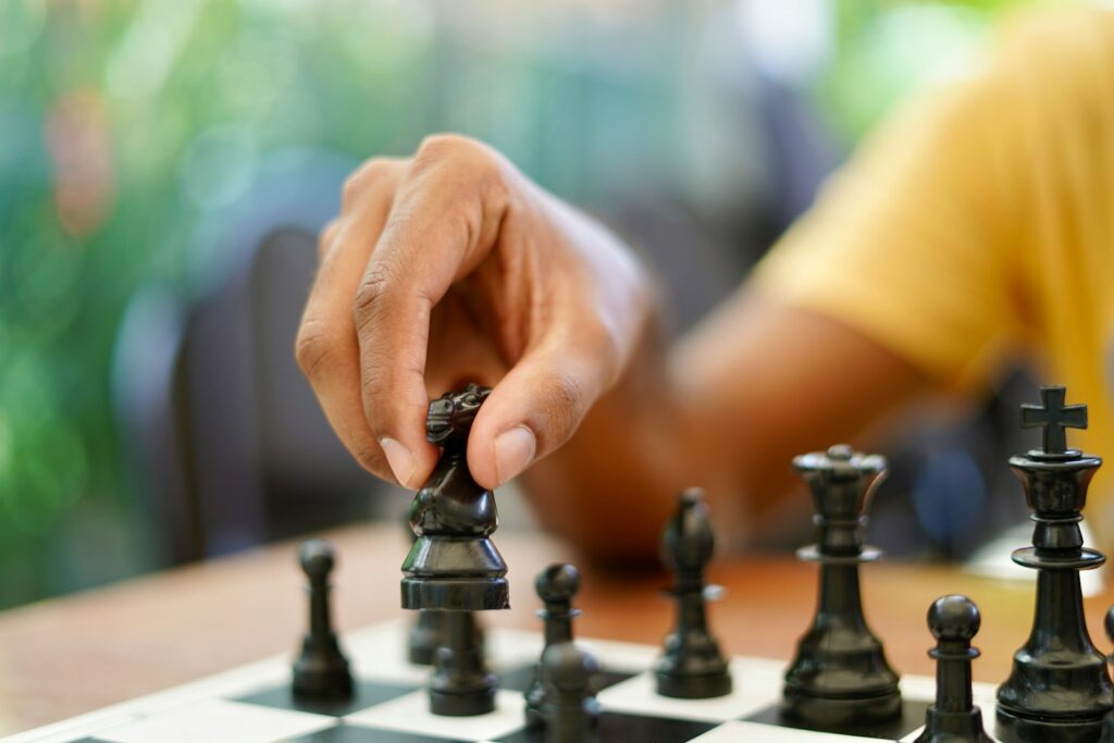 person holding black and silver chess piece