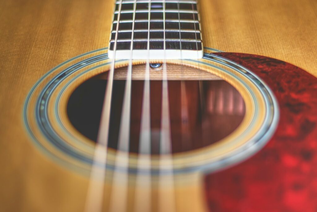 brown acoustic guitar in close up photography