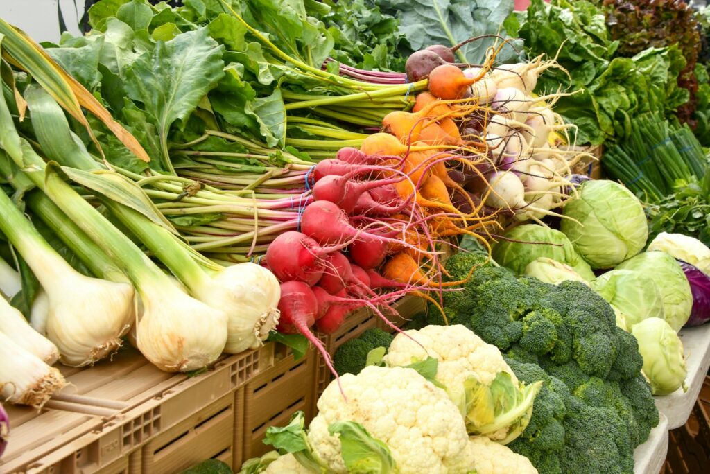 green and red vegetable on brown wooden table